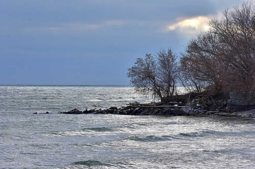 Rocky Lake Ontario shoreline beneath a blue sky